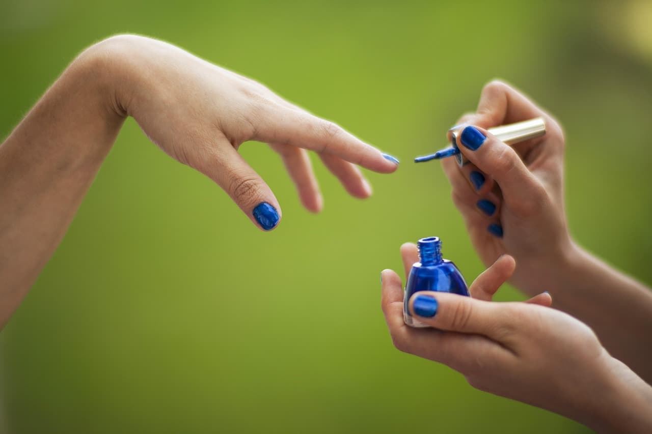 Blue nail polish being painted on
