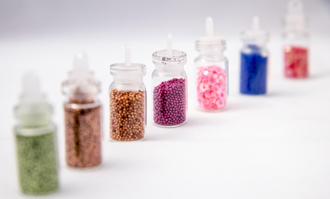 Small jars of nail glitter and gems