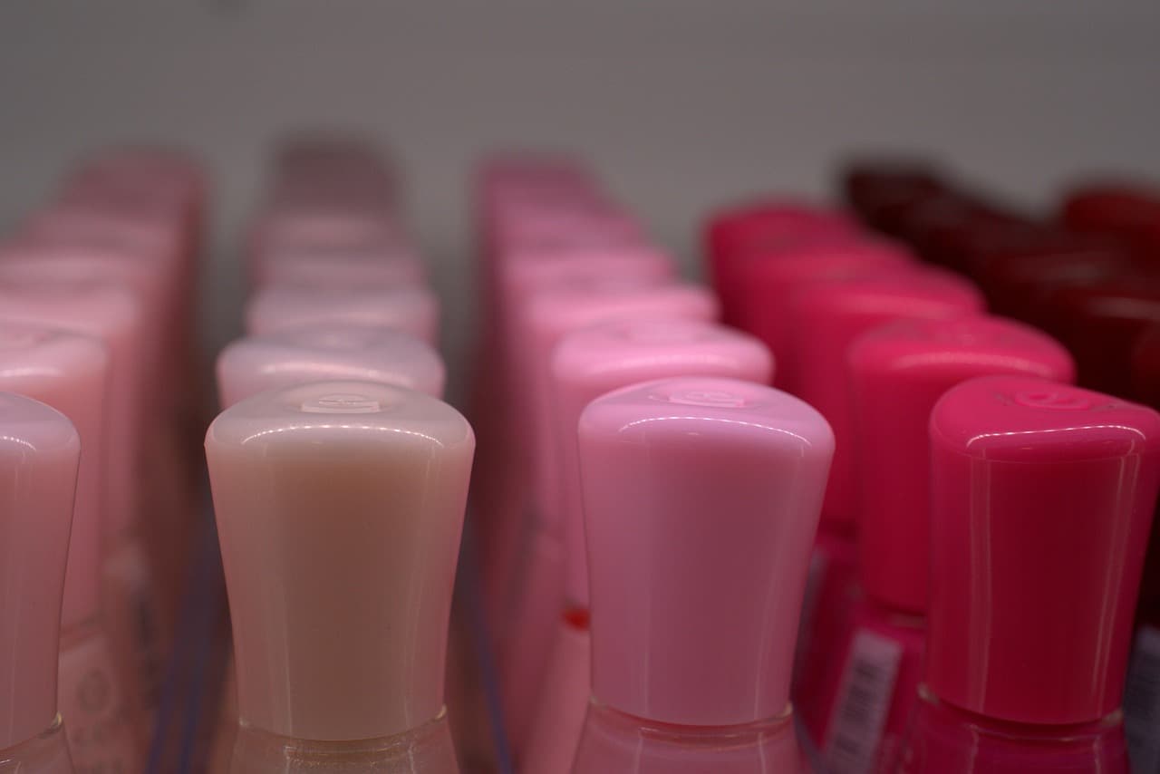 Rows of pink and red nail polish bottles